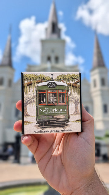 New Orleans Signature Collection black sleeve box held in front of St. Louis Cathedral